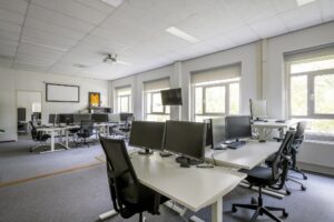 Moderne en lichte kantoorruimte aan de Van der Madeweg met meerdere werkplekken en computerschermen.